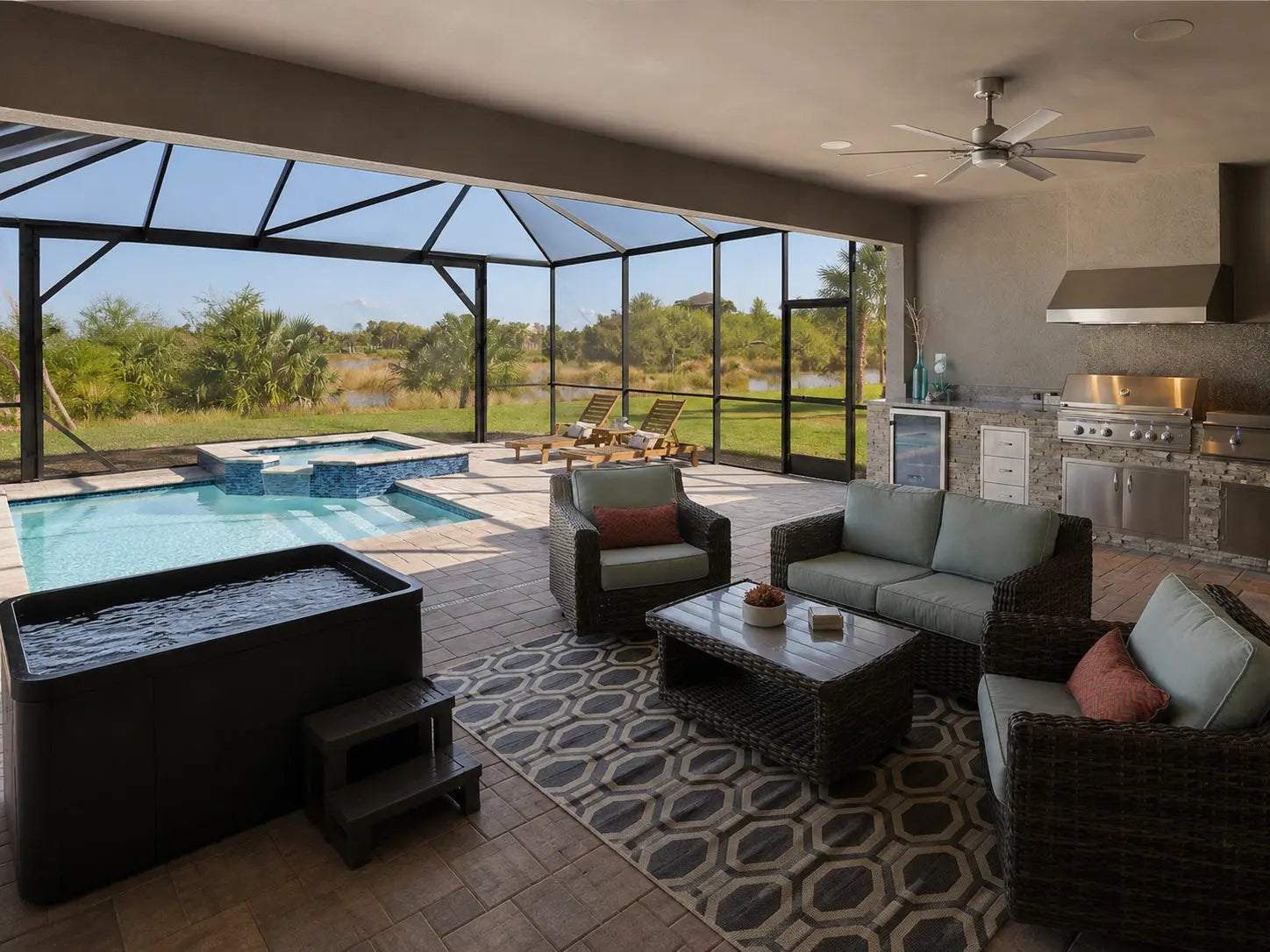 Black cold plunge tub on a screened Florida lanai beside a pool and spa with outdoor lounge and kitchen