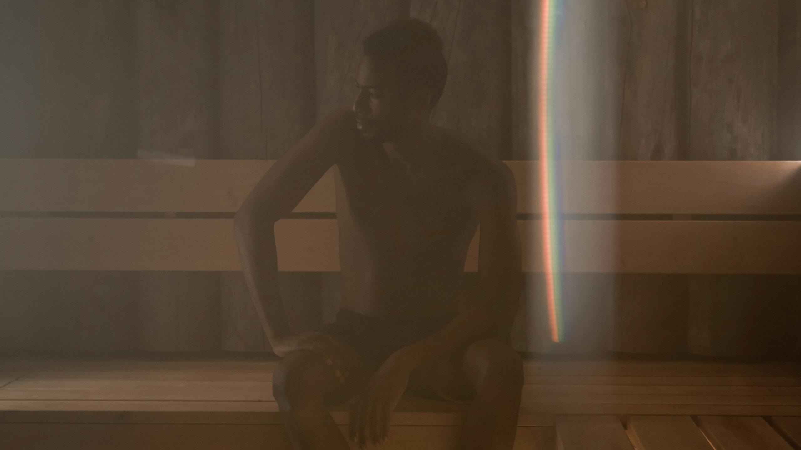 Man relaxing in a luxury sauna with warm steam and wellness atmosphere