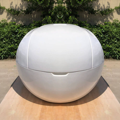 Dreampod Home Float Plus fiberglass flotation tank shown from the front on a wooden deck
