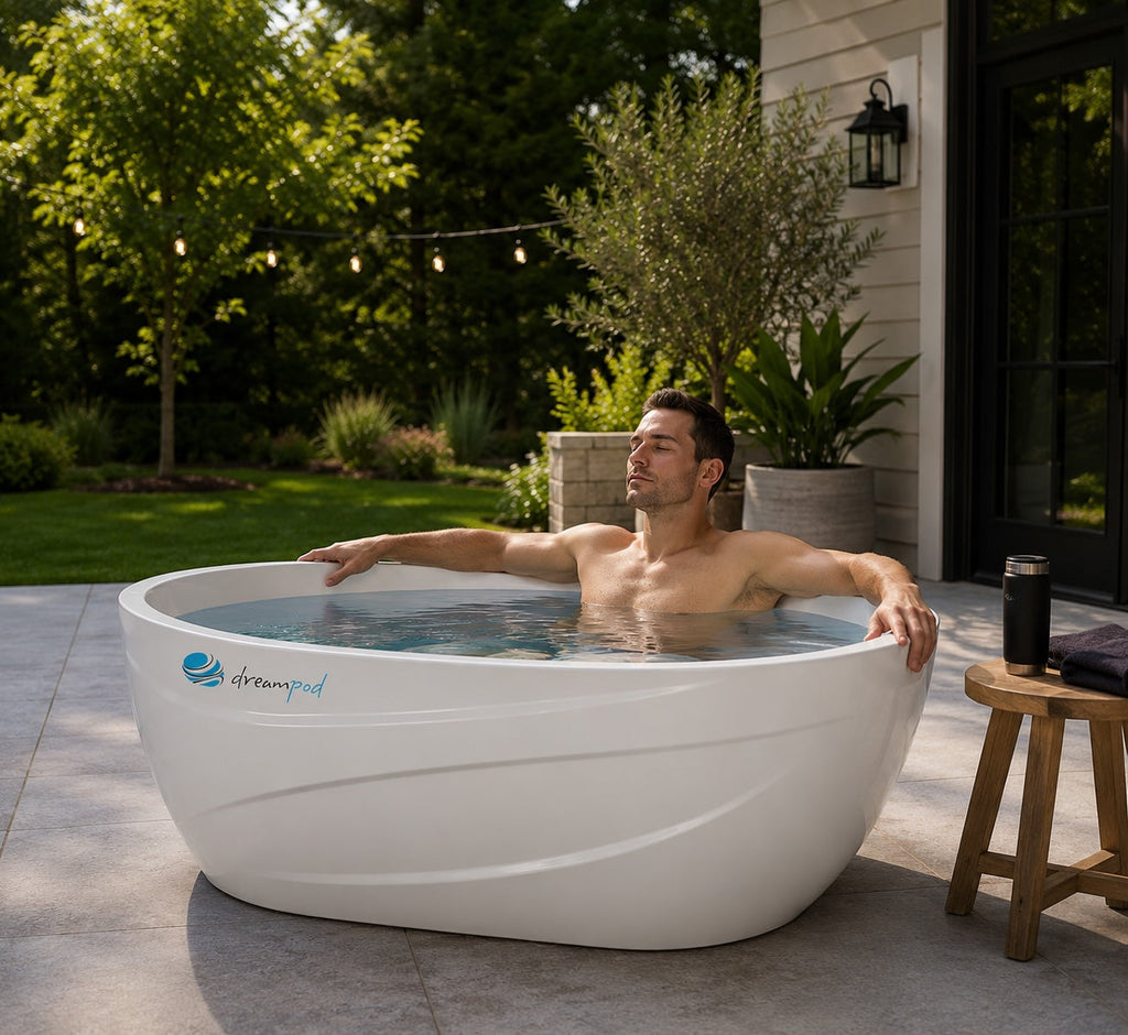 Person enjoying a DreamPod cold plunge on a luxury backyard patio designed for home wellness and recovery.