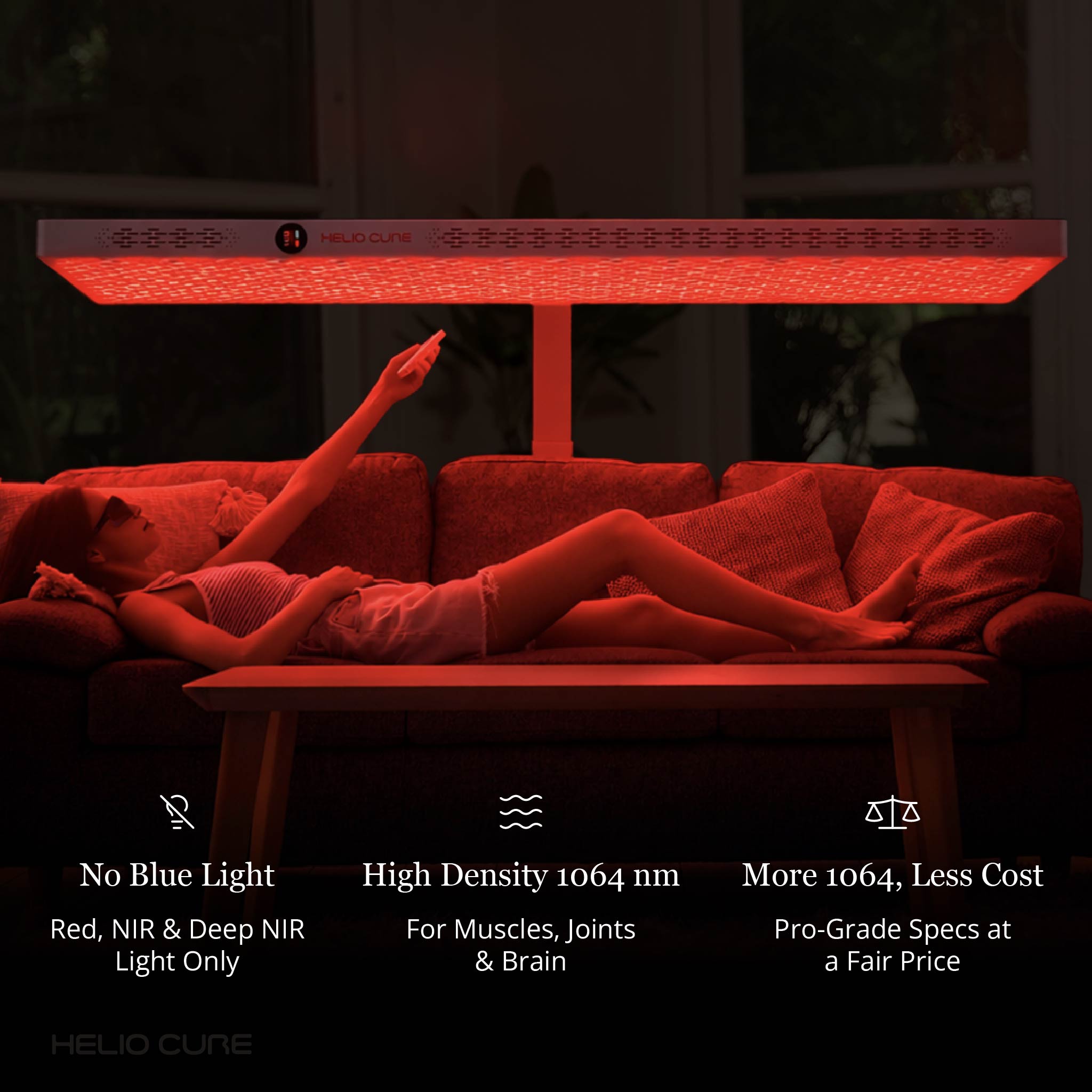 Woman relaxing on a couch beneath a horizontal Helio Nova red light therapy panel for full-body wellness and recovery.