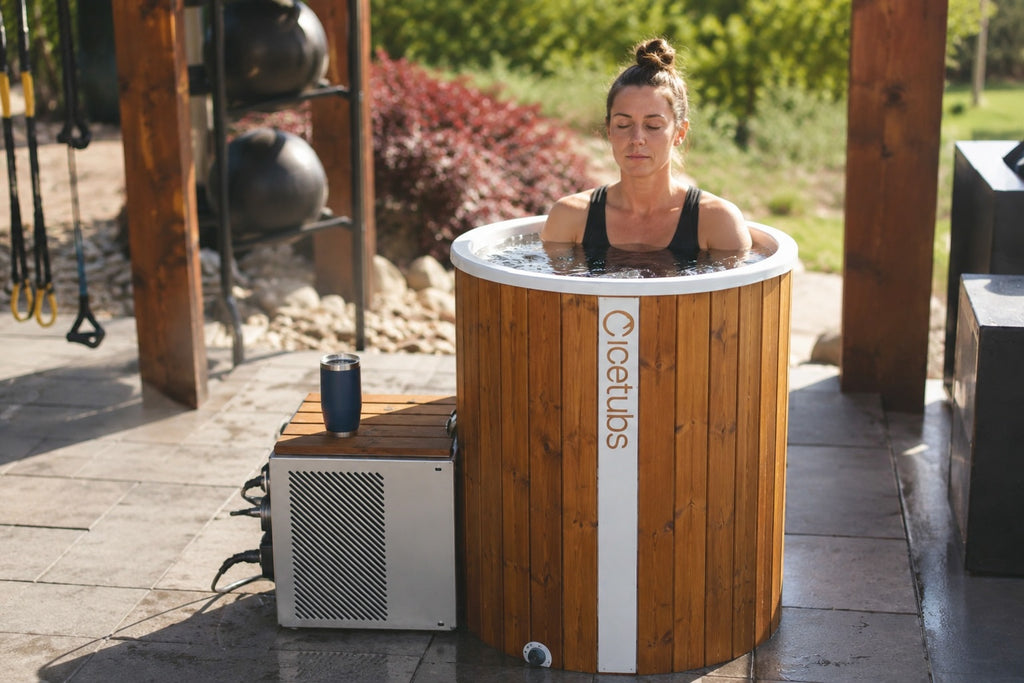 Woman using the Icetubs IceBarrel XL thermowood cold plunge tub during an outdoor recovery and wellness session.