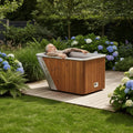 Man relaxing in the Icetubs IceBath thermowood cold therapy bath in a luxury outdoor wellness setting.