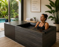 Woman using the Kohler x Remedy Place Ice Bath in a luxury Florida home wellness room with tropical outdoor views
