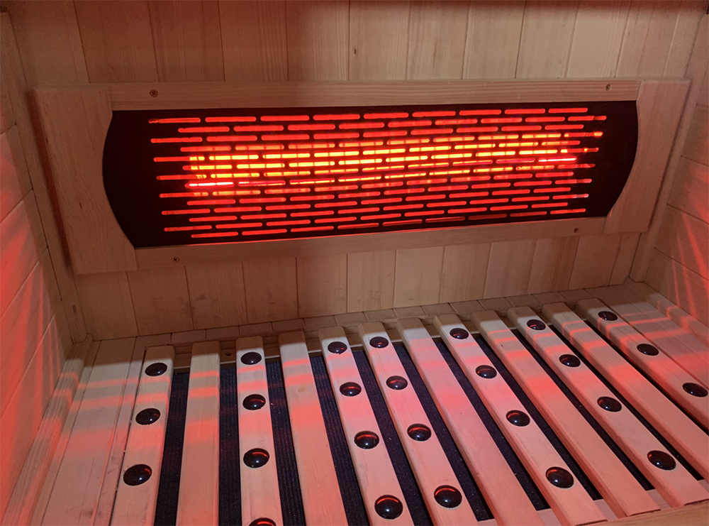 Close-up of infrared heating panels inside the Lumin Three sauna with glowing red therapeutic heat technology.