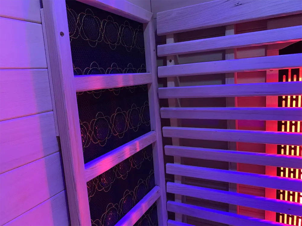 Interior of the Orivon Lumin Two infrared sauna with heating panels under violet chromotherapy lighting.