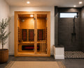 Indoor infrared sauna fitted into a custom bathroom wellness retreat with a frameless glass shower and modern finishes