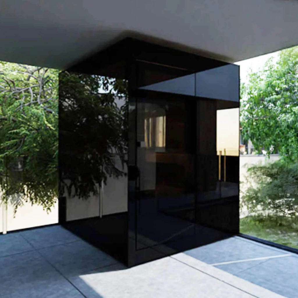 ThermaSol Vera outdoor sauna cabin in black glass on a covered patio, framed by greenery for a backyard wellness retreat.